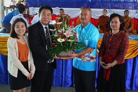 Suwat Rotchatwattanakul (2nd left), vice president of Nongprue PAO, presents flowers congratulating Suwat Nongyai, school licensee, with Waraporn Jandech, director of Pattaya Arunothai School, on the school’s 40th Anniversary.