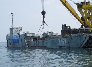 A barge with heavy crane tows the HTMS Mataphon out to its new home off Koh Larn, were the ship was sunk to begin its new “mission” as an underwater diving site near Koh Larn. Officials said the sinking will help restore the marine ecosystem and be a place of knowledge for students, residents and tourists.