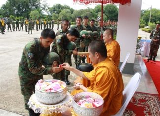 Monks bless the troops and hand out amulets for luck before the troops leave for the south.