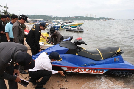Officials inspect and take photos of jet skis along Pattaya Beach in an attempt to end the national embarrassment of jet ski scams. 