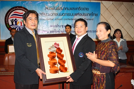 Confederation President Pornchai Pisarnsidkul gives Deputy Mayor Ronakit Ekasingh a gift for holding the meeting at City Hall. 