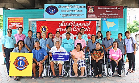 Somsak Nakson (left), treasurer of the Lions Club Chonburi Pratamnak, Pattaya, poses for a group picture with Pattaya Hospital officers and six patients who received wheelchairs. 