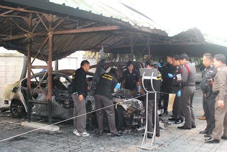 Police forensic officials inspect the scene of the fire. 