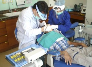 Jirasak being treated by dentist and assistant.