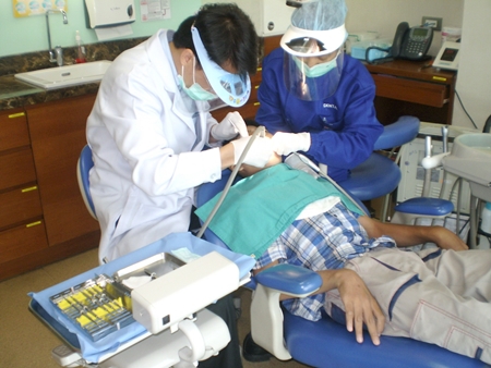 Jirasak being treated by dentist and assistant. 