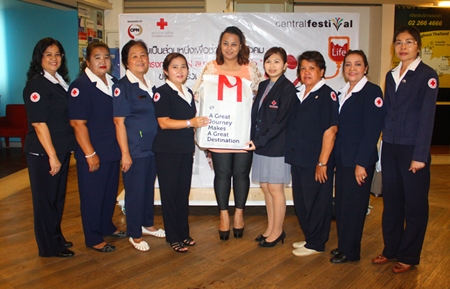 Aisika Songserm (center) poses for a group photo with members of the Banglamung Red Cross led by Nuanjan Saeng-Uthai (4th from left), and Phanisra Sukhjinda (4th from right) during the blood donation event. 