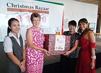 Central Festival presents toy collection totals to PILC president, Ann Winfield, and Ananya Welland, the special events chairperson