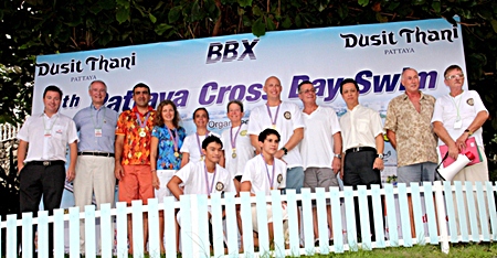 Neoh Kean Boon (3rd right), resident manager of Dusit Thani Pattaya poses for a photo with officials and some of the winners of the 9th Pattaya Cross Bay Swim. Dusit Thani Pattaya has sponsored beach towels and other essentials, buffet lunch for the swimmers and event organizers since the charity swim held its debut nine years ago.