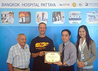 (L to R) Bernie Tuppin and Lewis “Woody” Underwood present a certificate of thanks to Neil Maniquiz, head of Bangkok Hospital Pattaya’s International Marketing and his deputy, Janya Rattanaliam.