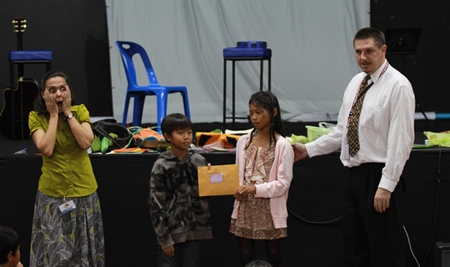 Primary students hand over a donation to the Hand to Hand Foundation.
