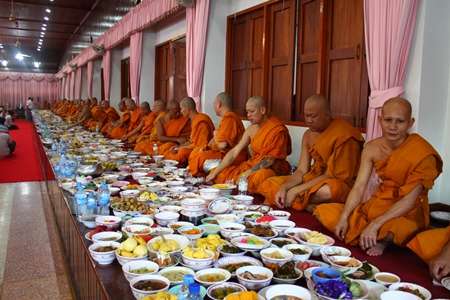 Monks at Wat Chaiyamongkol chant prayers and receive offerings in return.