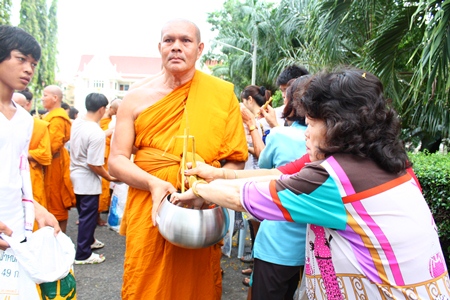 Citizens offer specially made Kaotom Hang or tailed sticky rice wrapped to the monks at the Devo ceremony on Wednesday October 31 morning. 