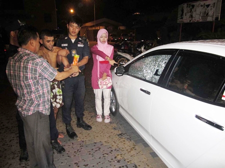 Police struggle to restrain Ayoub as the victim points out the damage he caused to her car. 