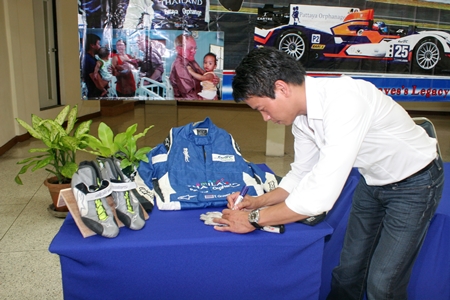 Tor Graves signs the jumpsuit, gloves and shoes he used in this year’s FIA World Endurance Championships. 