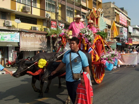 Sonthaya Kunplome and friends ride through the streets of Chonburi at the head of the opening day parade on a fabulously decorated buffalo drawn cart. (Photo from CPRD)