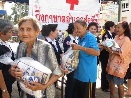 Happy residents pick up aid bags distributed through the Sattahip ‘Smile Mobile’ service program. 