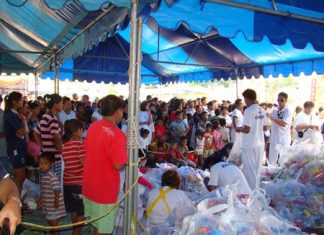 Sawang Boriboon Thammasathan workers distribute to the poor 1,700 packages of food and necessities donated by attendees of its annual vegetarian festival.