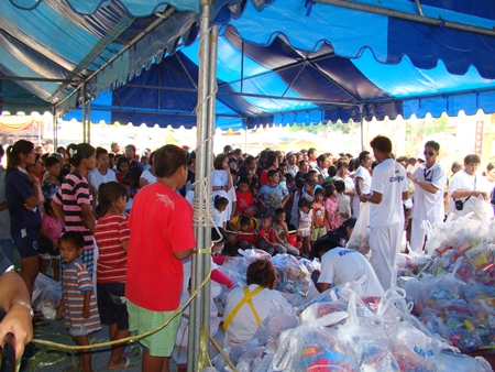 Sawang Boriboon Thammasathan workers distribute to the poor 1,700 packages of food and necessities donated by attendees of its annual vegetarian festival.