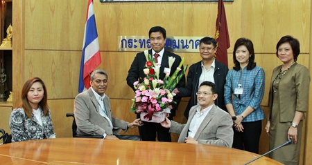 Suporntum Mongkolsawadi (seated right) and his committee presents flowers to Chatchart Sitthipan from the Ministry of Transport. 