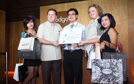 Hotel operations director Gerard Walker (2nd left) and Peta Ruiter (2nd right), director of business development, present Dr. Kitikhun Roongruang (center) with the top prize in Hilton Pattaya’s Dine & Fly contest. 