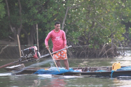 A fisherman lays out his net, which will spread out over 2 km.