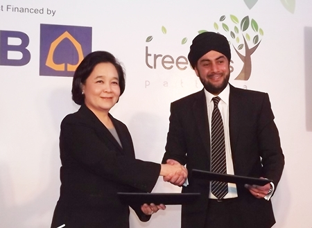Kluaymai Thephasadin Na Ayutthaya, Vice President Siam Commercial Bank (left), providers of project finance for Treetops, exchanges contracts with Prab Thakral, founder of Thai-based Thakral Land Ltd. (right) at the press conference held Nov. 24.