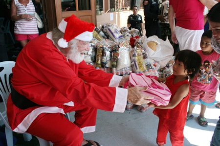 Santa Claus distributes gifts to thankful, but sometimes wary children.