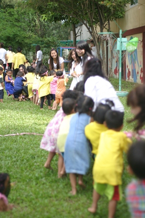 The college students take part in a tug of war with the children. 