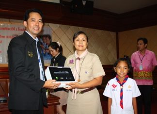Mayor Itthiphol Kunplome presents one of the new tablet computers to a teacher and student from Pattaya School No. 1.