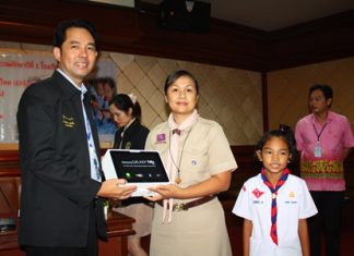 Mayor Itthiphol Kunplome presents one of the new tablet computers to a teacher and student from Pattaya School No. 1.
