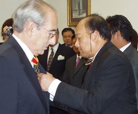Baron Carini, left, receives his award from Ambassador Vikrom Koonpirochana.