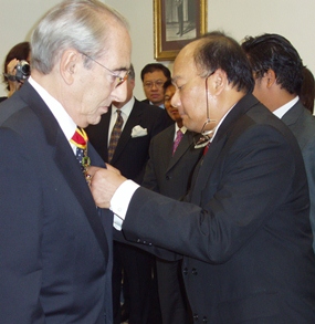 Baron Carini, left, receives his award from Ambassador Vikrom Koonpirochana.