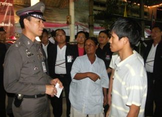 Somwang Rodkanphai (center) tells Pol. Maj. Gen. Khatcha Thatsart (left) about the attack on her 2 sons.