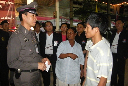 Somwang Rodkanphai (center) tells Pol. Maj. Gen. Khatcha Thatsart (left) about the attack on her 2 sons. 