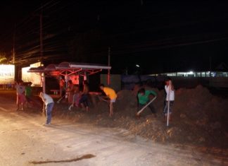 Workers hurriedly remove the dangerous pile of dirt before anyone else is injured.