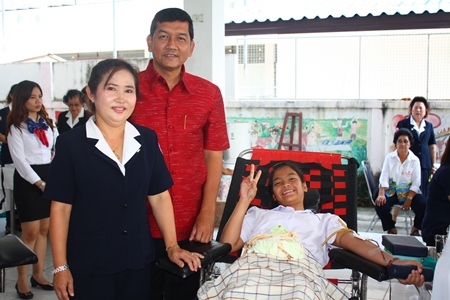 Banglamung District Chief Chaowalit Saeng-Uthai (center) and his wife Banglamung Red Cross President Nuanjan Saeng-Uthai (left) provide encouragement to Banglamung student donating blood.