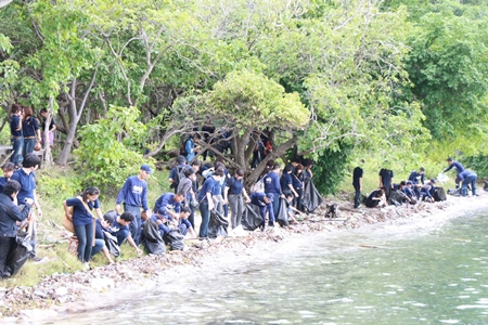 Navy sailors join up to 300 people to help clean up the shores and plant coral around Koh Khram. 