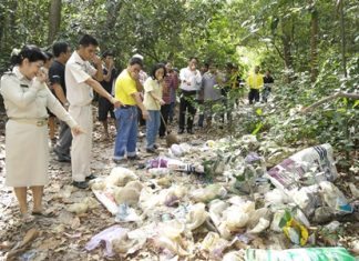 Residents clean park victimized by illegal trash dumpers Village Chief Watcharee Vichiensakulchot (left) leads residents and workers to clean up after the typically irresponsible behavior of leaving garbage in their national park.