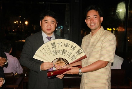 Mayor Itthiphol Kunplome (right) presents Yuan Zhongxue with a key to the city and receives a hand painted fan in return.