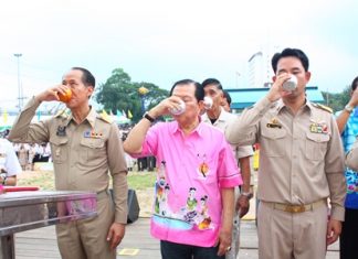 (L to R) Chonburi Governor Khomsan Ekachai, MP Santsak Ngampiches, chairman of the parliamentary Arts and Culture Committee; and Mayor Itthiphol Kunplome, drink blessed water to swear an oath to Their Majesties the King and Queen in the campaign against drugs.