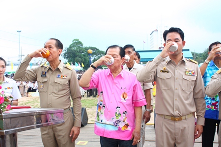 (L to R) Chonburi Governor Khomsan Ekachai, MP Santsak Ngampiches, chairman of the parliamentary Arts and Culture Committee; and Mayor Itthiphol Kunplome, drink blessed water to swear an oath to Their Majesties the King and Queen in the campaign against drugs. 