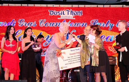 Brenda Foster from the UK is thrilled as she receives the grand prize of two round-trip air tickets Bangkok - Chiang Mai, courtesy of Thai Airways International including 2 nights stay at D2 Hotel Chiang Mai from Chatchawal Supachayanont (3rd right), GM of Dusit Thani Pattaya during the Mardi Gras New Year’s Eve party held at the resort.