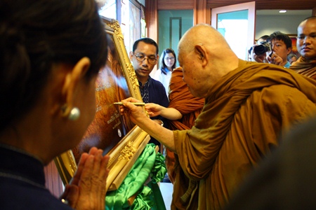 Luangphor Viriyang autographs a portrait of himself on arrival at the Diana Garden Resort.