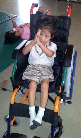 Here is Fahsai in her new wheelchair thanking all of you with a big ‘wai’.