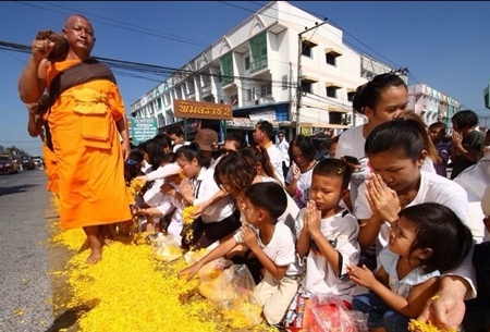Citizens sprinkle marigold petals on the rose way during the “Dhammachai Dhutanga” pilgrimage. (Photo from www.dmc.tv)