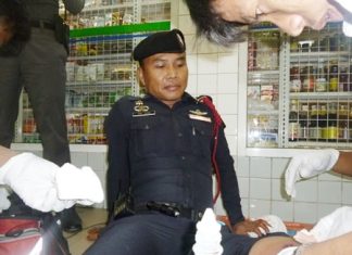 Emergency workers tend to Sgt. Ruangchai Prachaipoom’s gunshot wound to his leg.