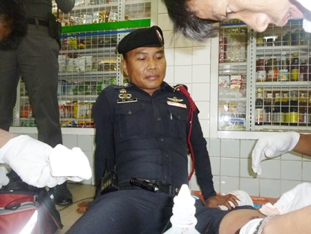 Emergency workers tend to Sgt. Ruangchai Prachaipoom’s gunshot wound to his leg.