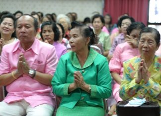 Mrs. Pranee Maneesarn (center), president of the Pattaya Elderly Club, with club committee members pray and receive blessings from monks during their New Year celebrations.