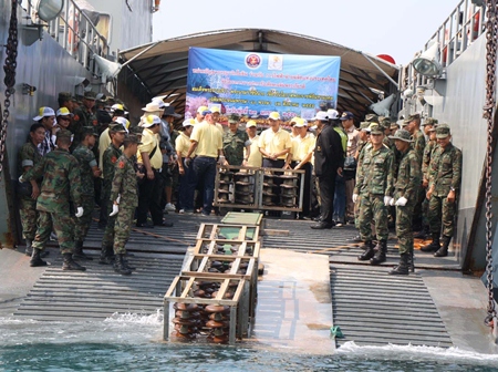 EGAT officials and Royal Thai Marines throw overboard high-voltage insulator bulbs to be used to form a foundation for artificial coral reefs.