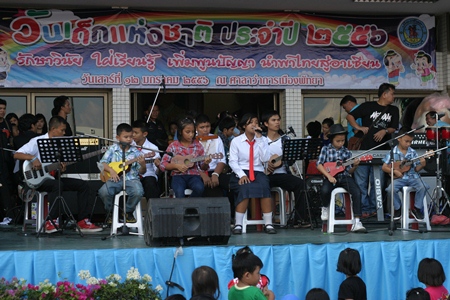 Pattaya schoolchildren give a rousing ukulele performance while their friends stand on the sides providing encouragement.